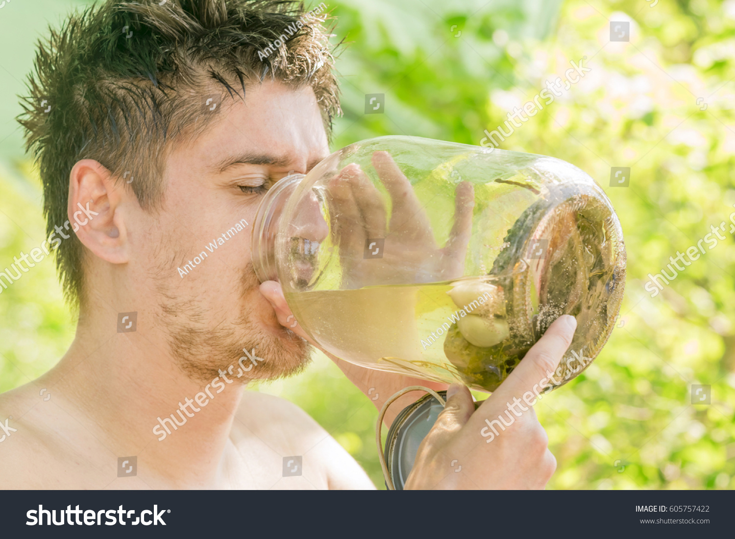 stock-photo-man-is-drinking-the-brine-from-the-jar-with-pickled-cucumbers-605757422.jpg